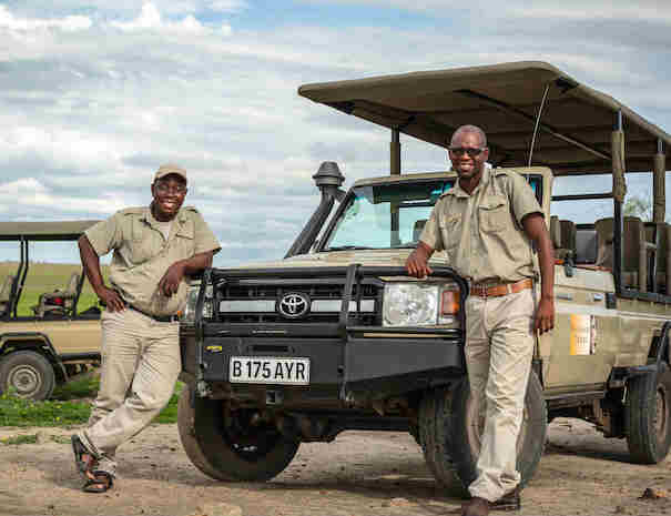 Guides standing with game drive vehicles